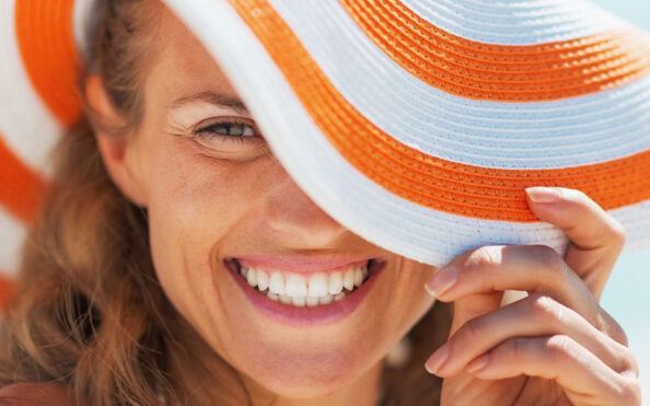 portrait of happy young woman in swimsuit and beach hat